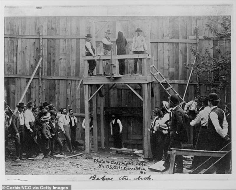 una folla attende sotto una piattaforma dove tre uomini stanno accanto a un uomo incappucciato con un cappio al collo, condannato all'impiccagione. carrolltan, missouri. 1896