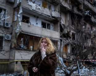 una cittadina di kiev piange davanti al suo appartamento distrutto
