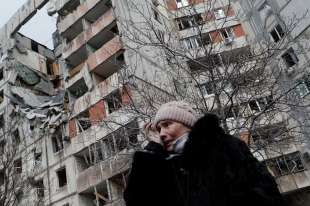 una donna in lacrime davanti a un palazzo distrutto a kiev