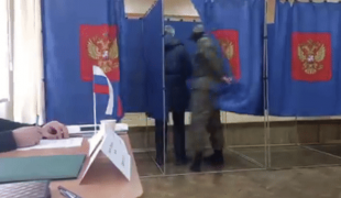 soldato russo controlla voto al seggio 3