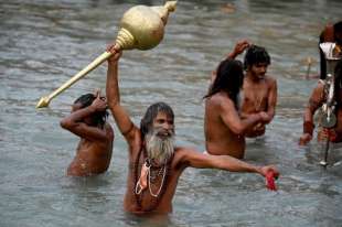 pellegrini fanno il bagno nel fiume gange