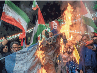 teheran iraniani festeggiano dando alle fiamme bandiere israeliane e statunitensi