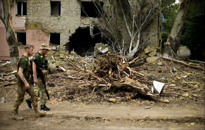 militari ucraini passano davanti a un edificio gravemente danneggiato in un bombardamento russo a bakhmut, ucraina orientale
