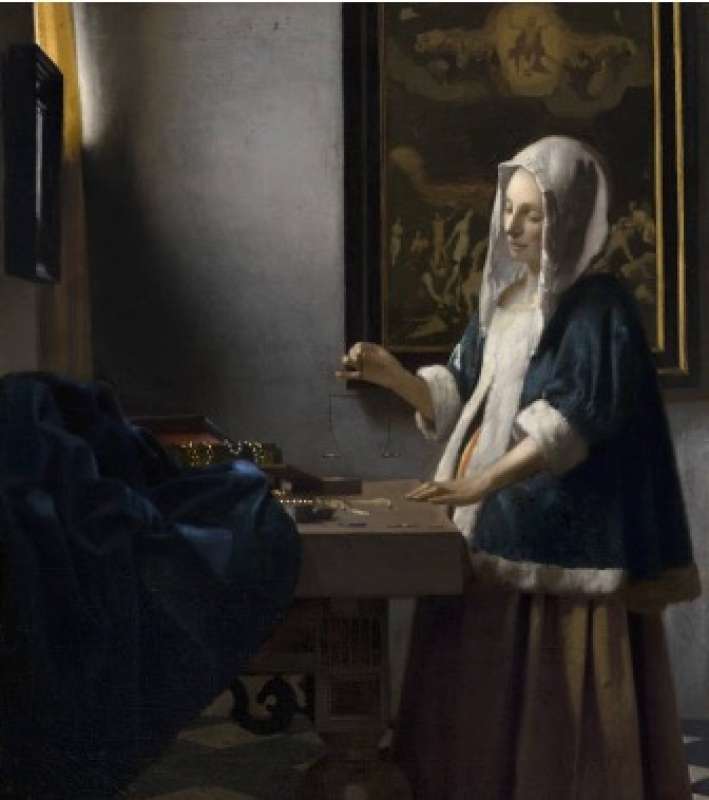 woman holding a balance johannes vermeer