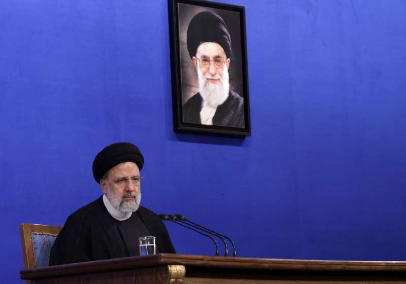 ebrahim raisi con un ritratto di khamenei nel 2022