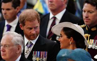 meghan sorrise mentre la coppia prendeva posto prima dell'inizio del servizio, segnando il loro primo pari al fianco della famiglia reale in due anni