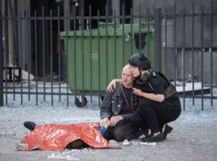 poliziotta consola un padre disperato accanto al corpo del figlio ucciso dai russi a kharkiv