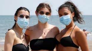 tre ragazze in spiaggia con la mascherina